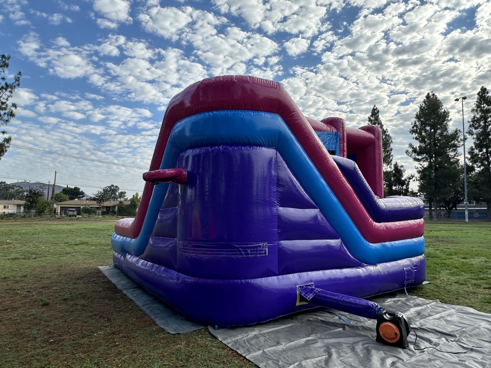 6n1 pink banner combo bounce house rental in San Diego, back view of the purple slide climb with the blower attached