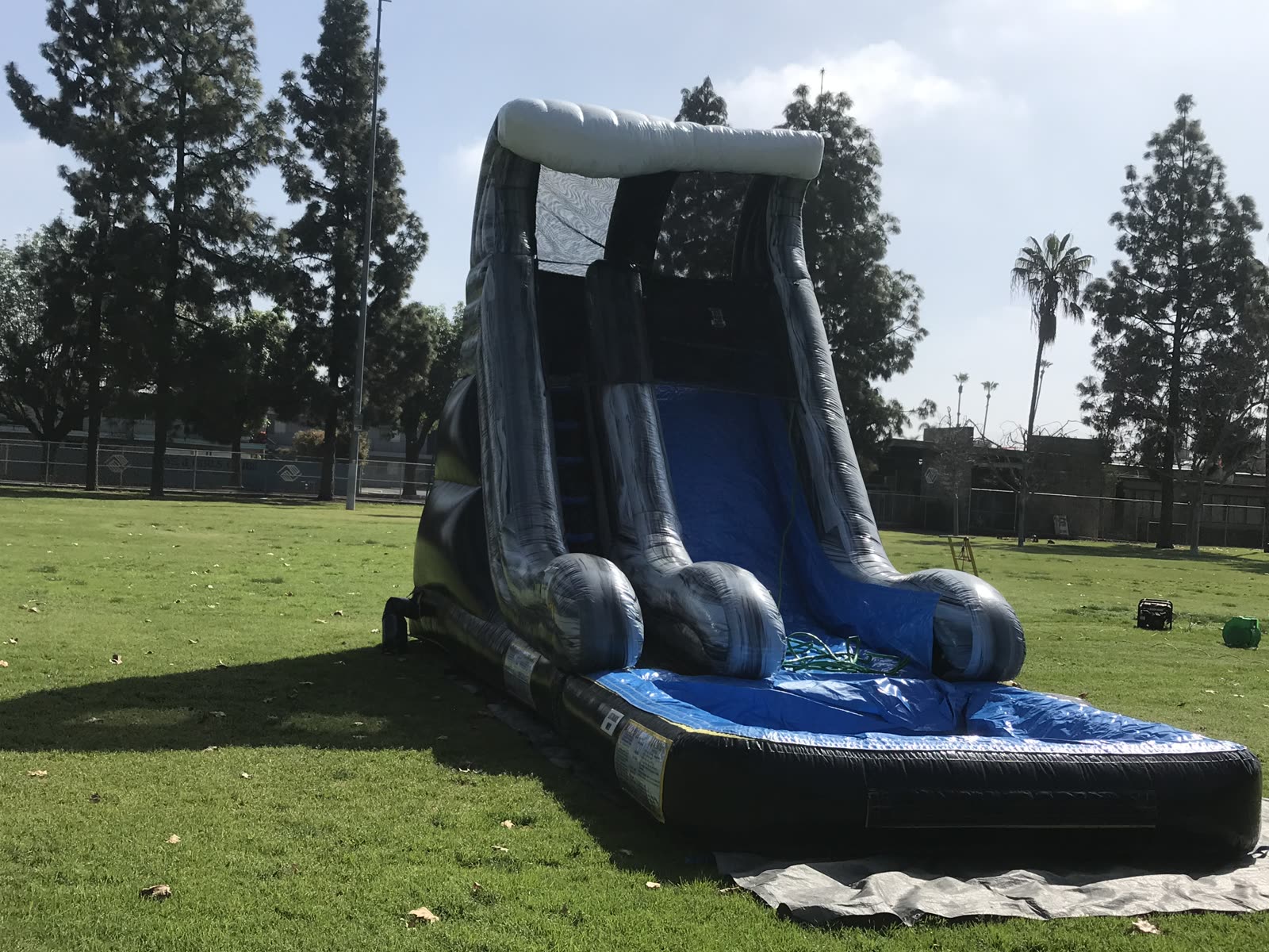 Water slide rental in San Diego, 18ft wave setup angled view on a school field showing the climbing lane