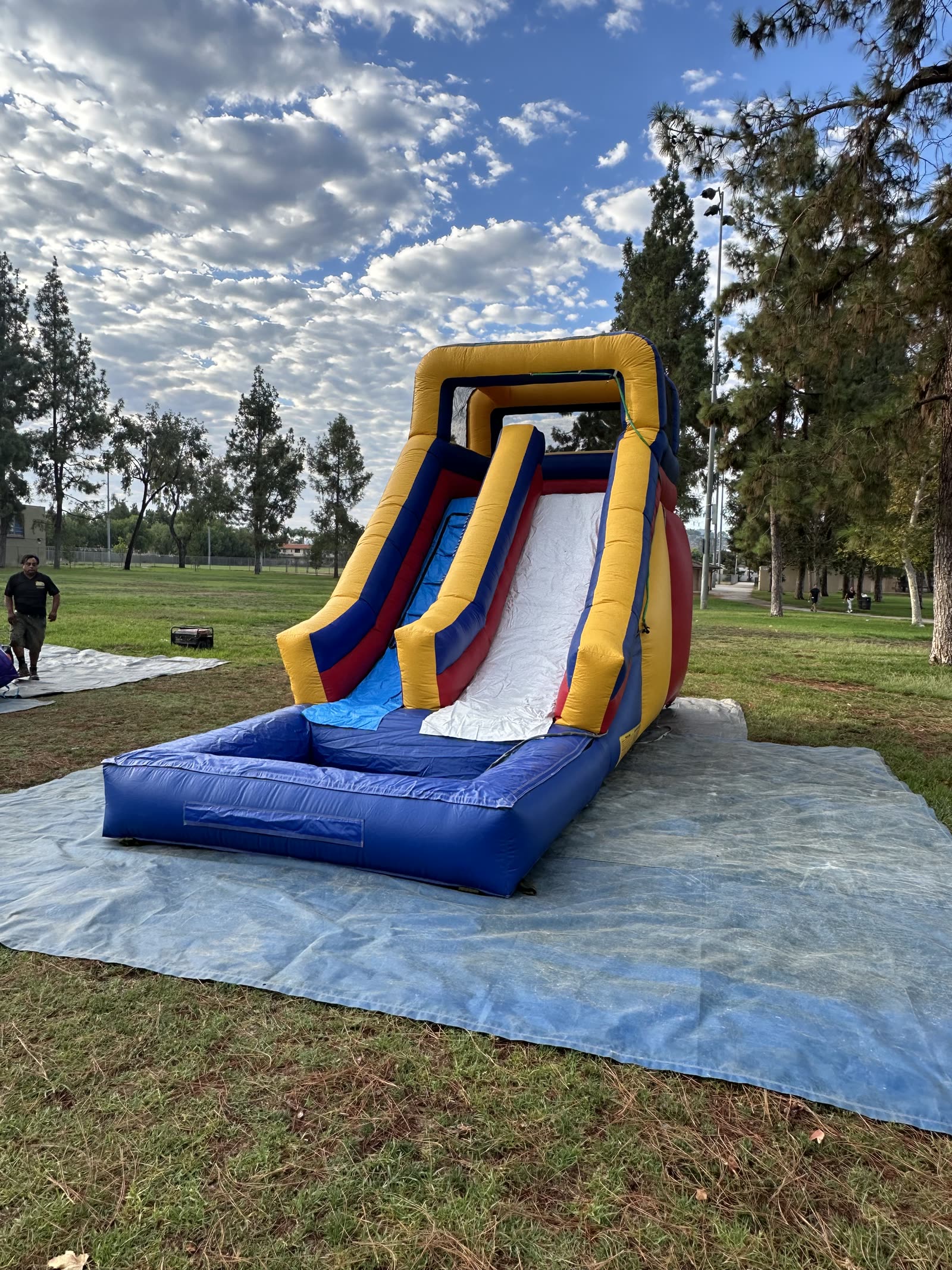 Water slide rental in San Diego, 15ft multi color water slide angled view showing the full slide lane and yellow side walls