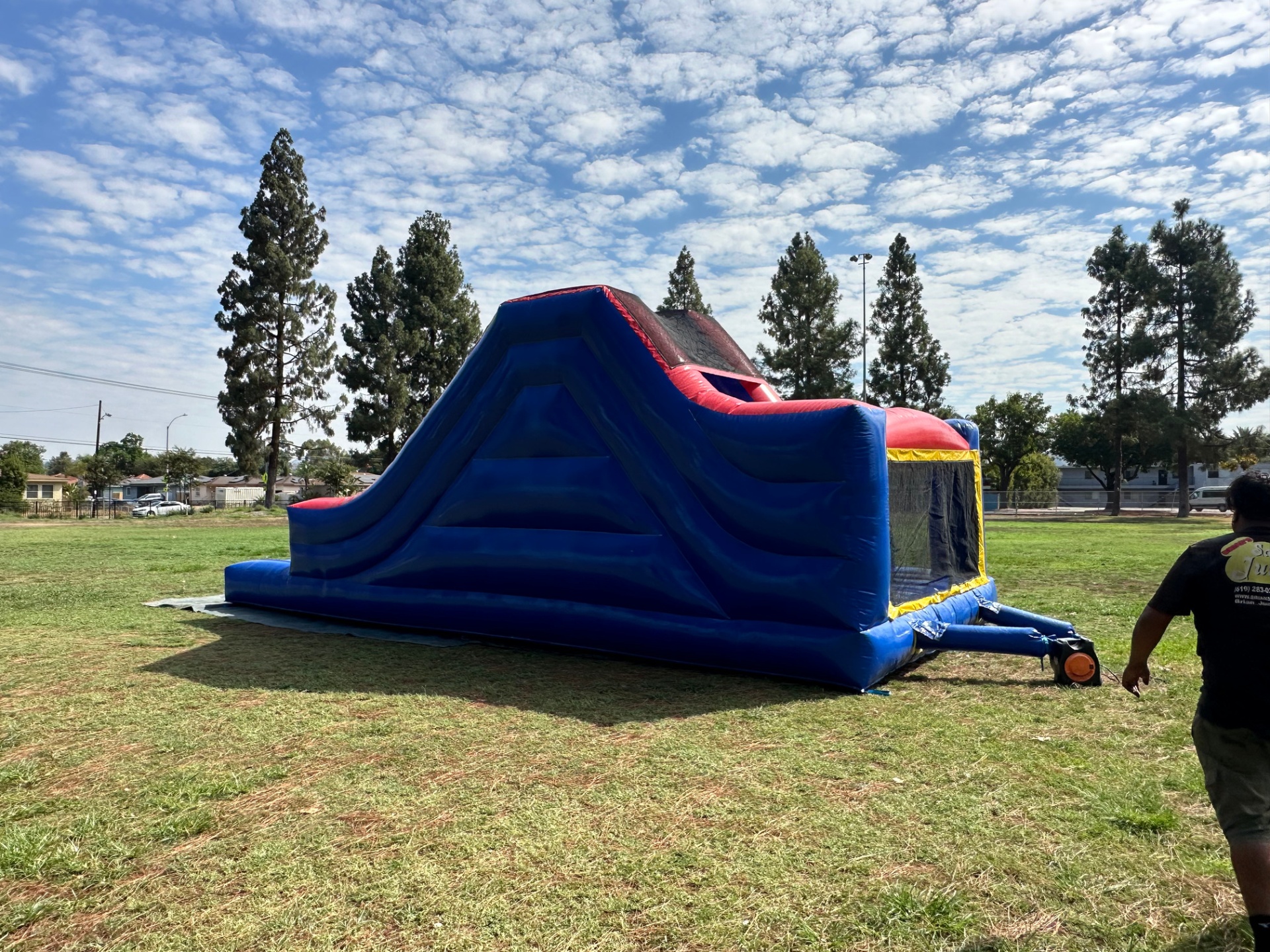 Challenge course obstacle rental in San Diego, blue and red lane, rear view of the tall blue slide and the run-out landing area