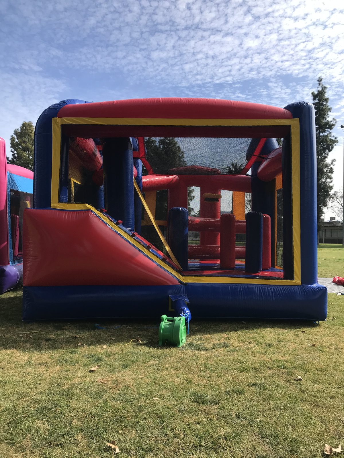 5n1 blue castle banner combo bounce house rental in San Diego, back view of the red slide and pop-up obstacles inside