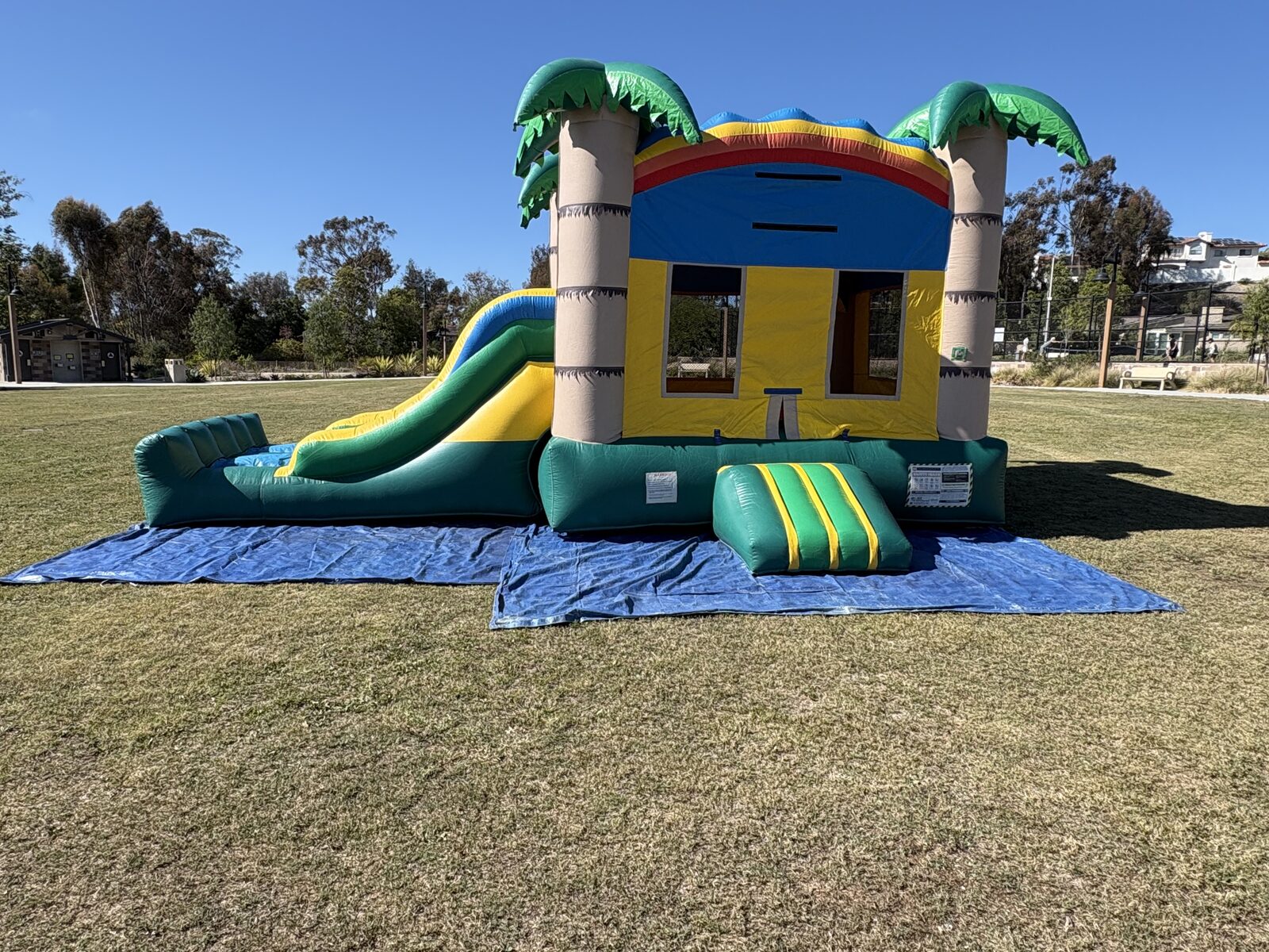 3n1 palm tree combo bounce house rental in San Diego, wide view of the full unit staked down at a park