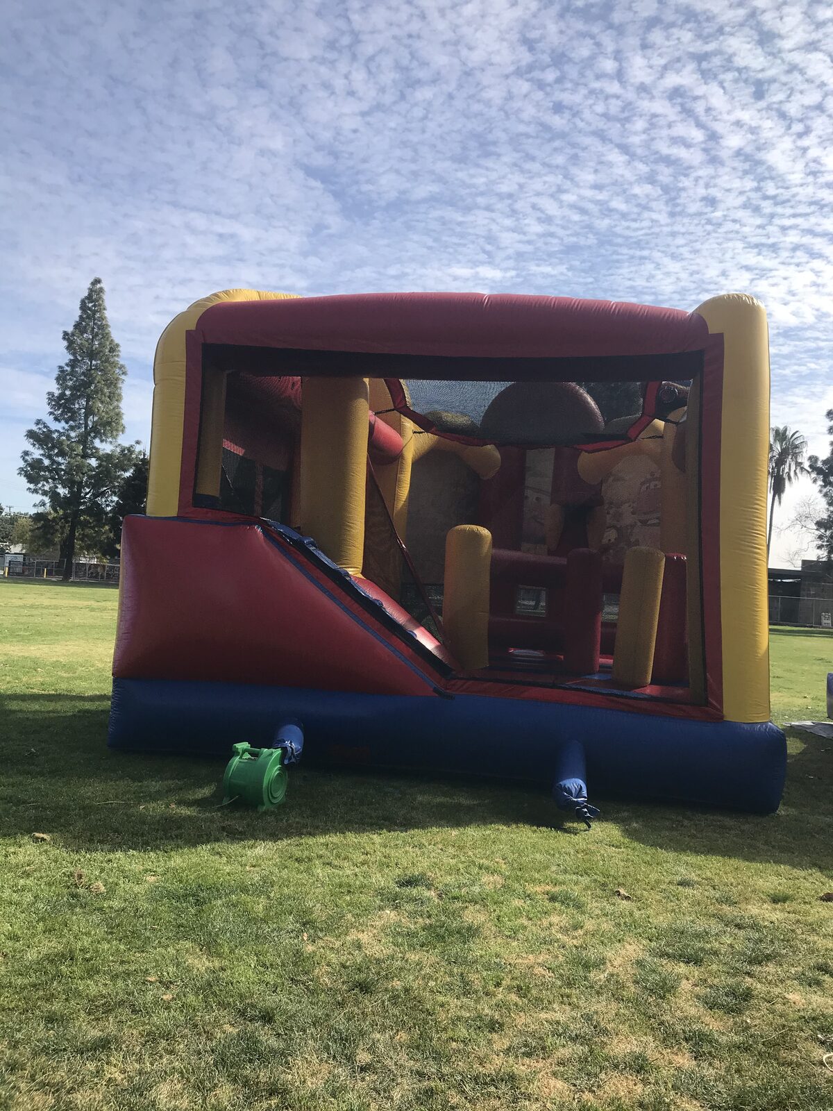 5n1 cars combo bounce house rental in San Diego, rear view of the open jump area showing the interior slide, climb-up and padded obstacle columns with the blower running