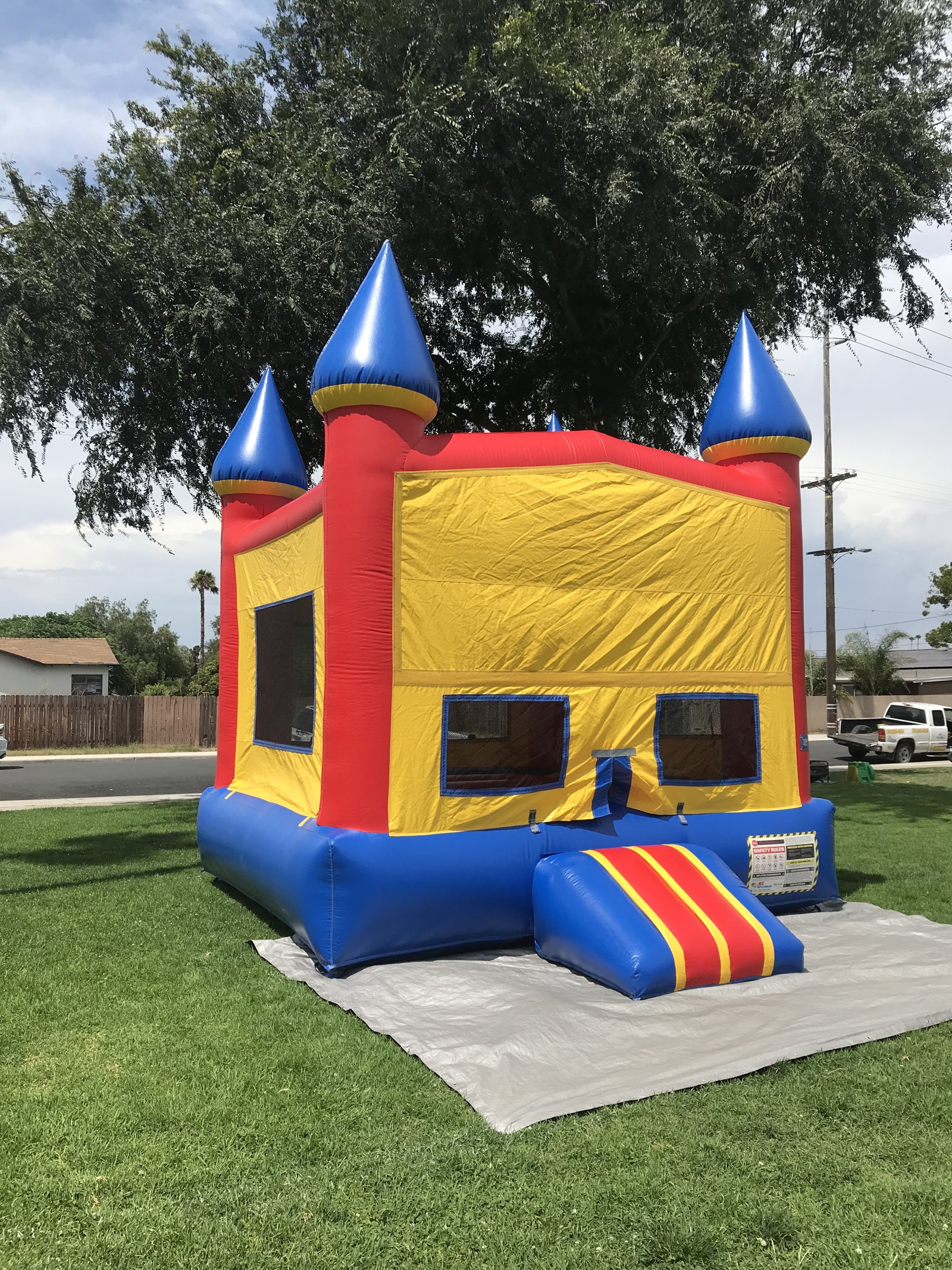 13x13 Blue Castle Banner bounce house rental in San Diego — side-angled view showing the yellow banner panel and blue base