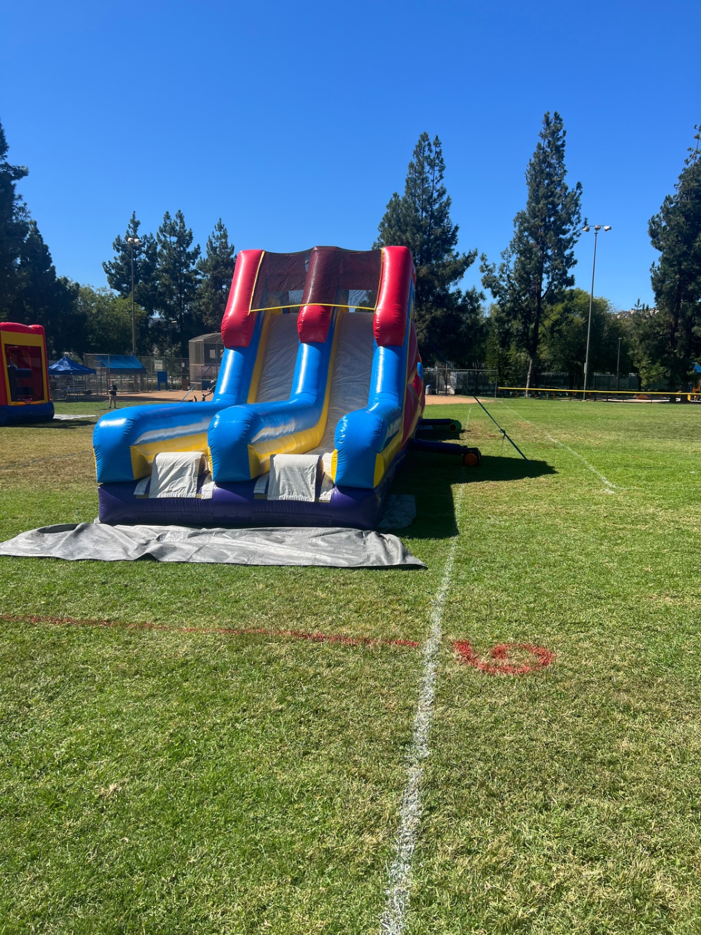70ft monster obstacle course rental in San Diego, straight-on view of the dual slide lanes and landing mats