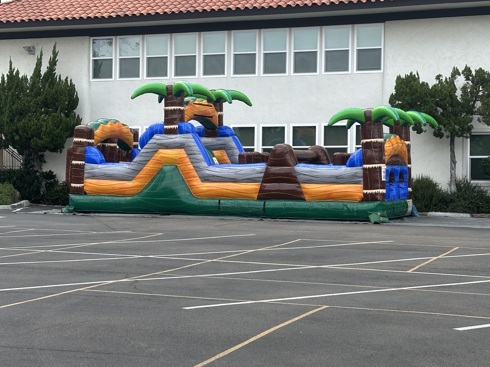 30ft tropical obstacle course rental in San Diego, full side profile of the course set up in a school parking lot