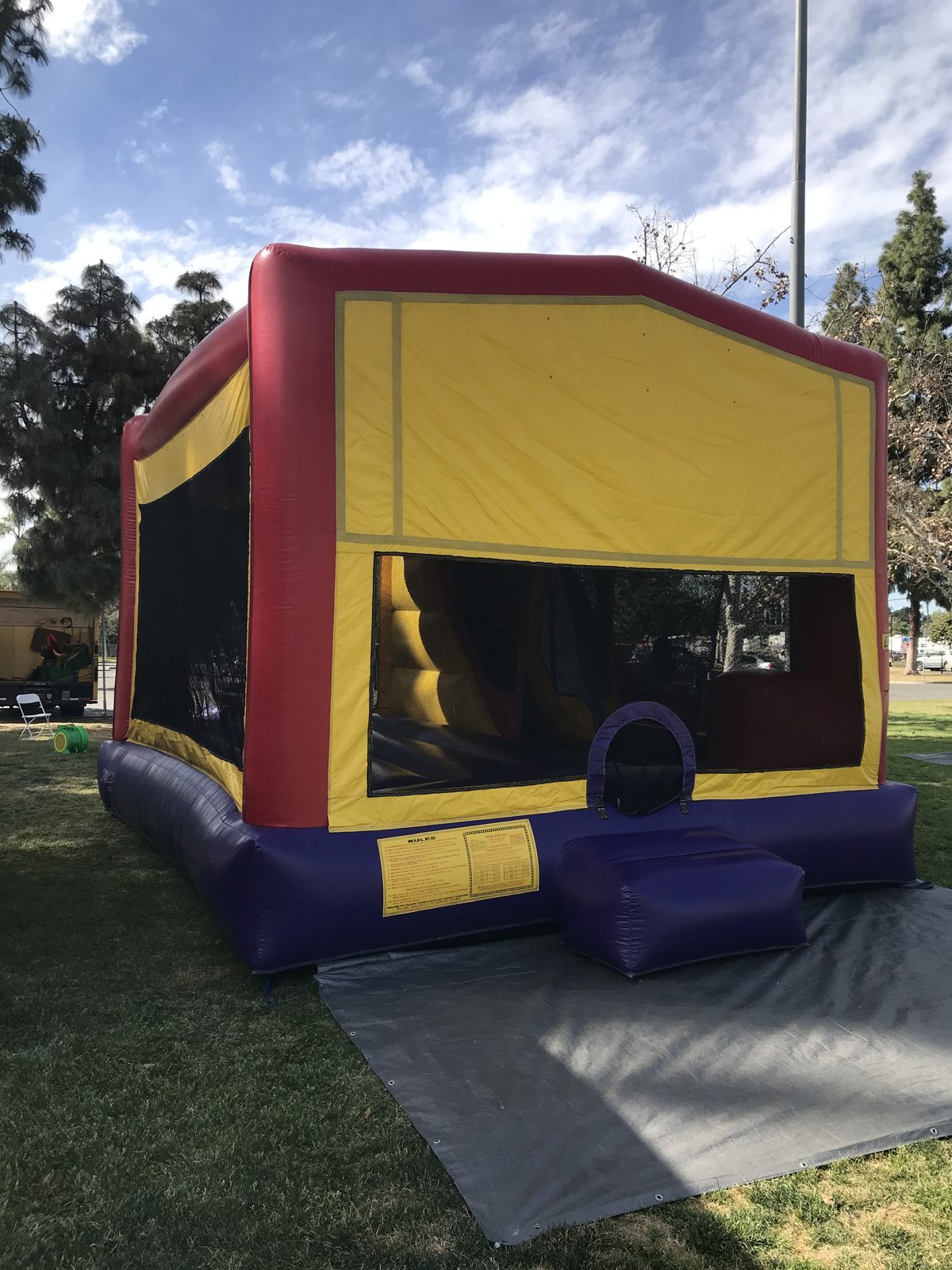 4n1 banner combo bounce house rental in San Diego, angled front view of the mesh windows and basketball hoop inside