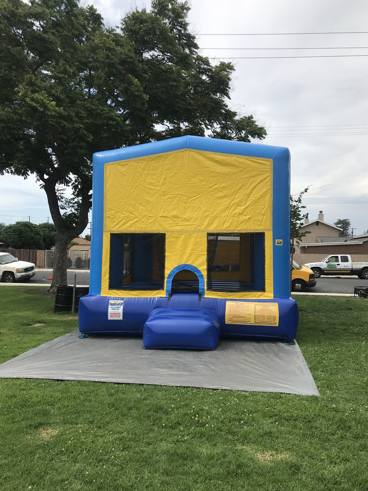 13x13 blue banner bounce house rental in San Diego — front view set up on grass with the blue safety ramp at the entry
