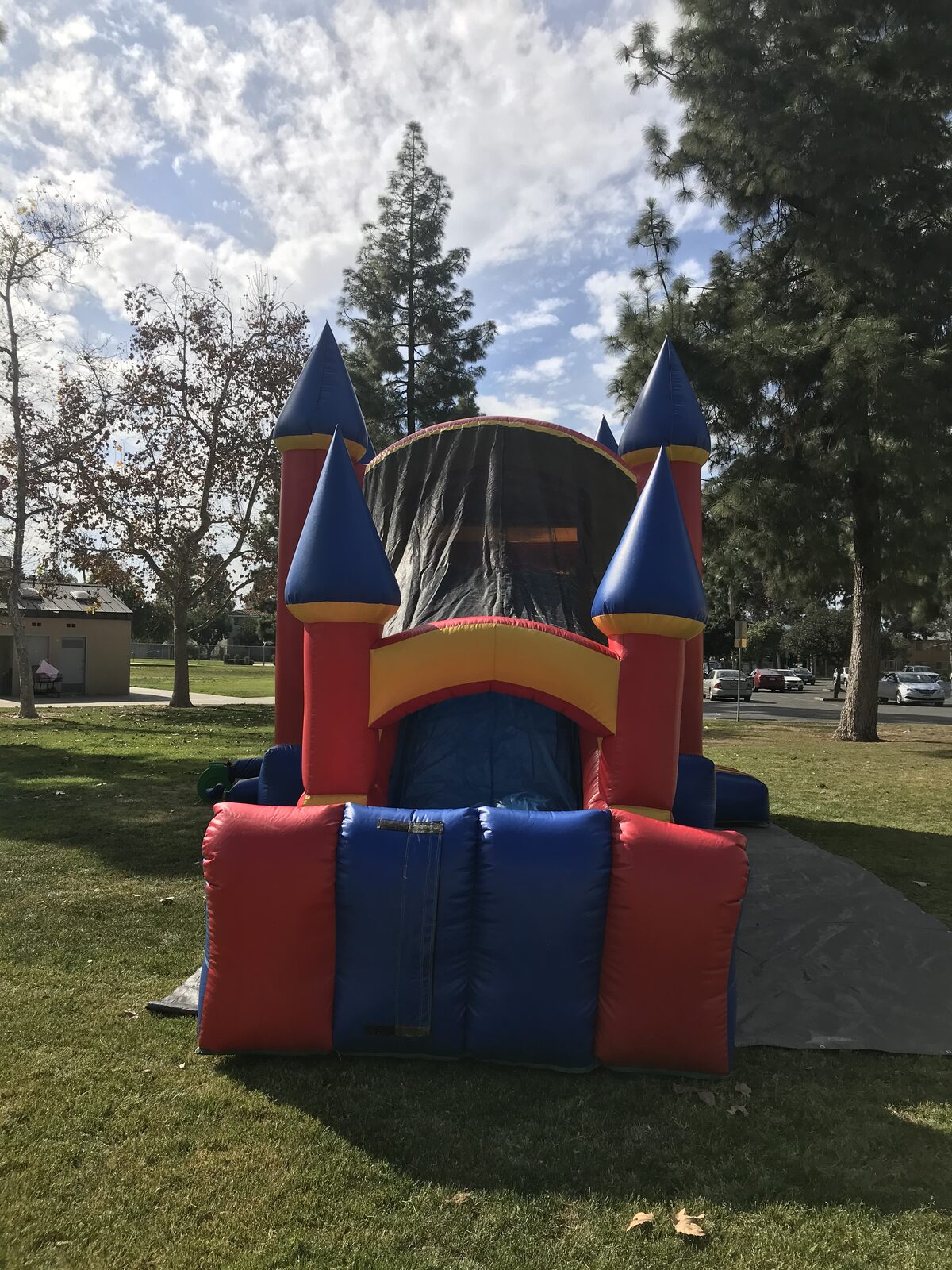 4n1 blue castle banner combo bounce house rental in San Diego, straight-on view of the slide exit framed by blue turrets