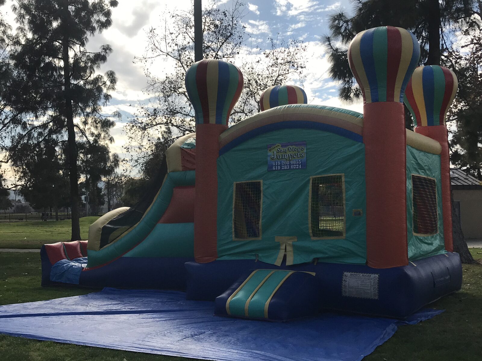 4n1 summer balloon combo bounce house rental in San Diego, angled view showing the mesh jump windows and the full side slide