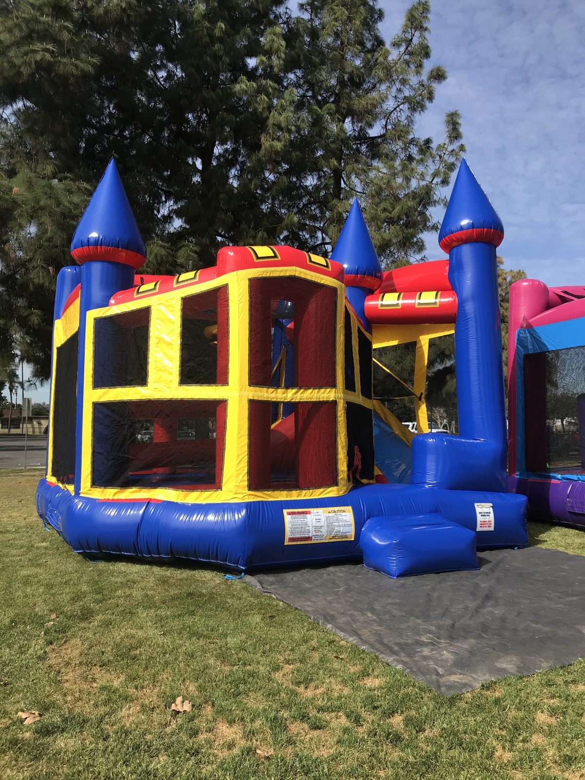 5n1 blue castle banner combo bounce house rental in San Diego, front view with the tall blue corner turret and entry ramp
