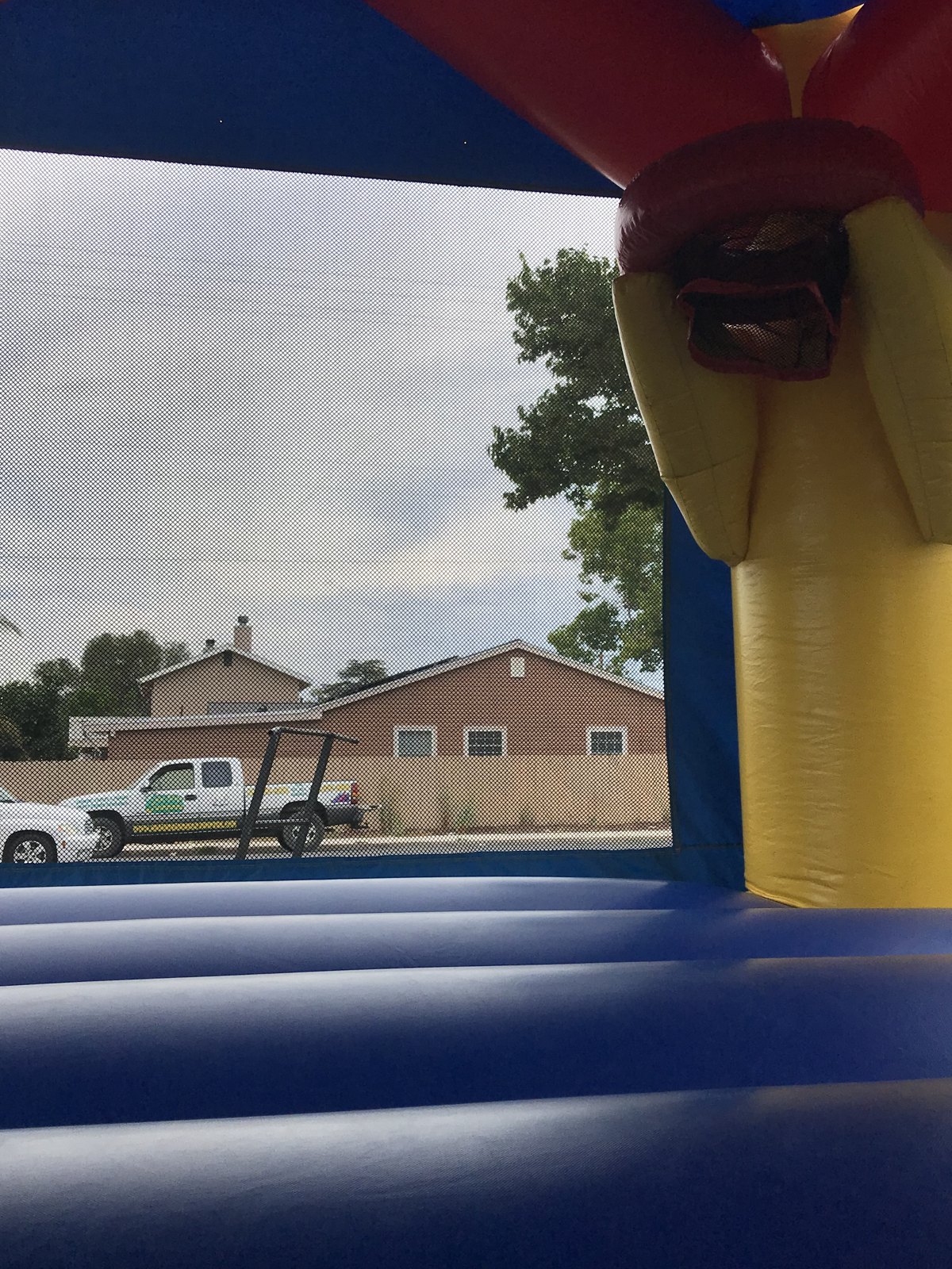 13x13 Disney's Cars bounce house rental in San Diego — inside view of the blue jumping floor looking out through the mesh safety window