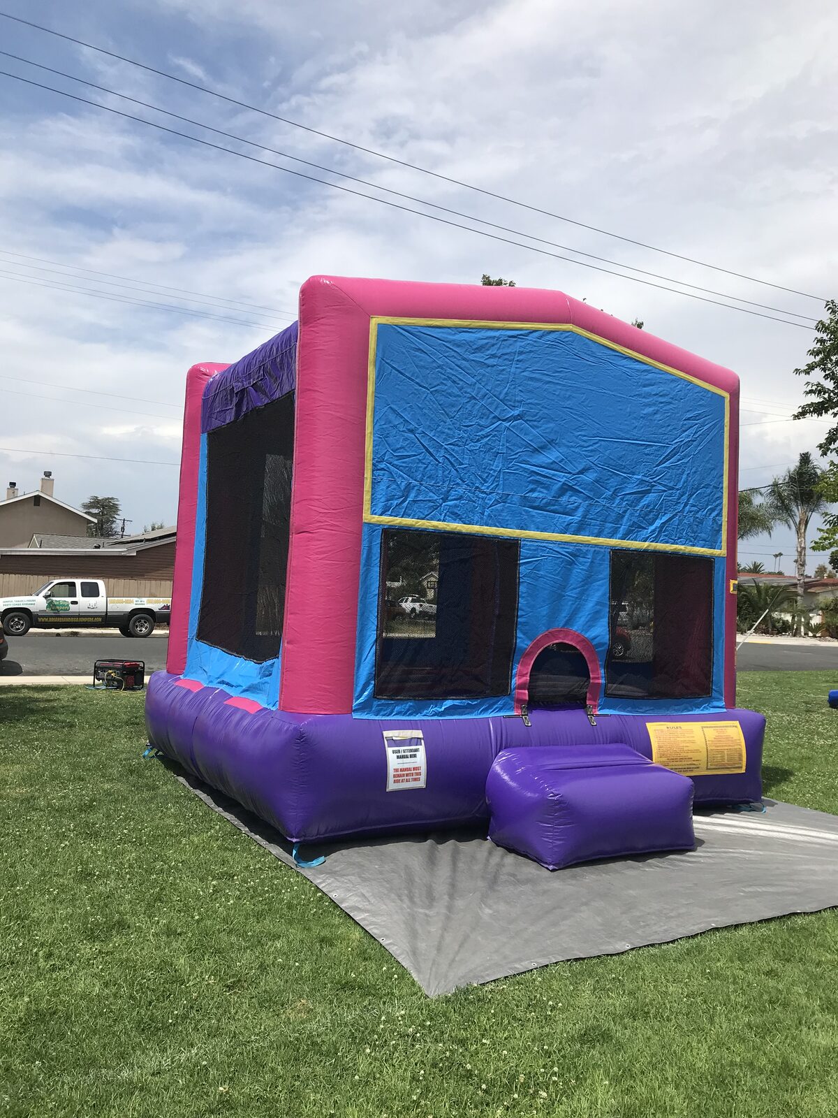 13x13 pink banner bounce house rental in San Diego — side-angled view showing the mesh safety windows and purple base