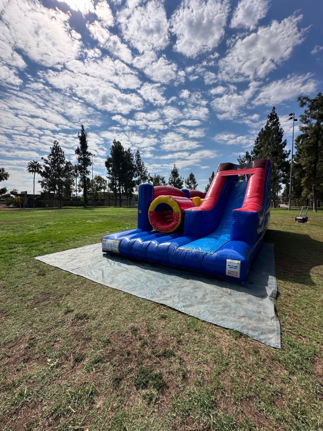 Challenge course obstacle rental in San Diego, blue and red lane, front view of the round tunnel entry and slide landing