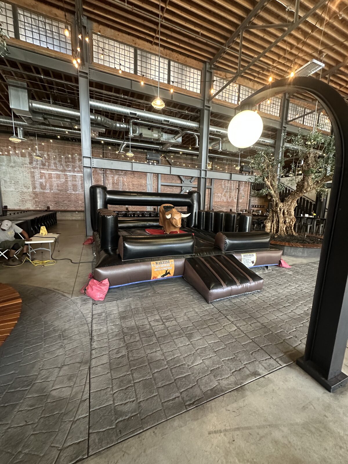 Mechanical bull rental in San Diego, 13x13 setup inside an indoor event venue with string lights