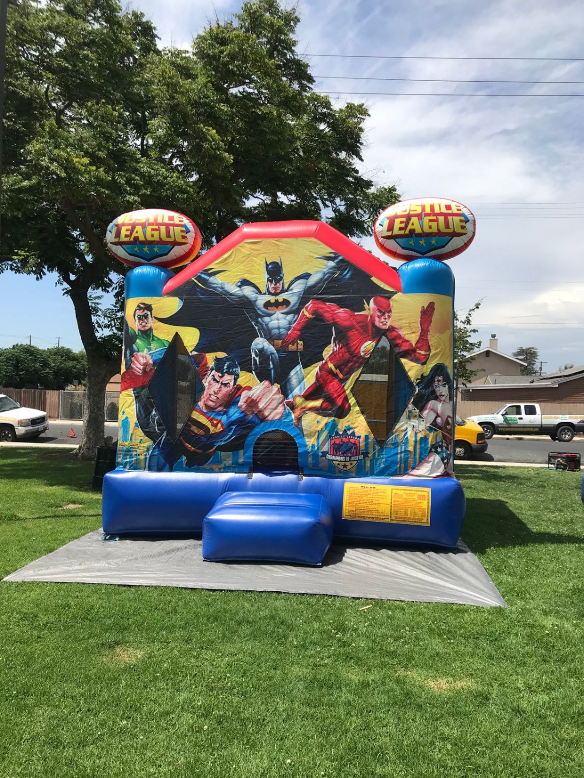 13x13 Justice League bounce house rental in San Diego — front view with Batman, Superman, Flash, and Wonder Woman art panel and Justice League corner toppers