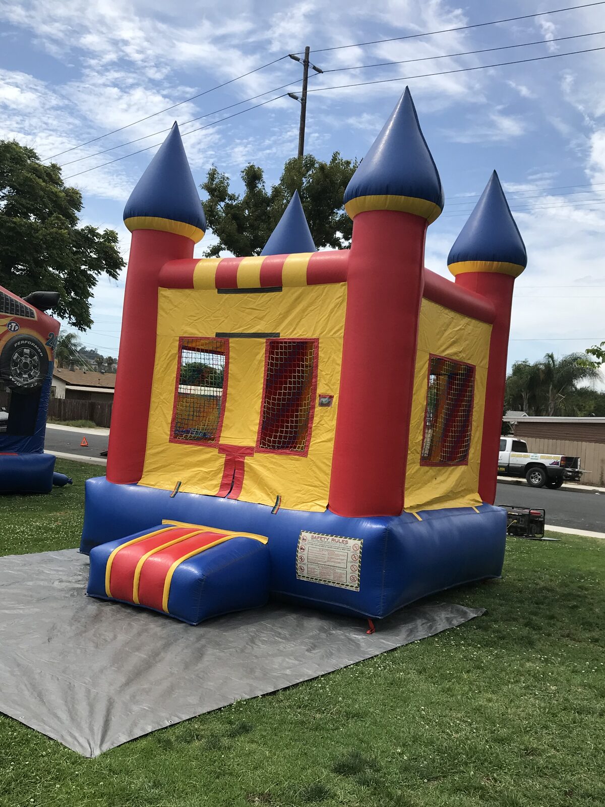 12x14 blue castle mini bounce house rental in San Diego, three-quarter view showing the side mesh window