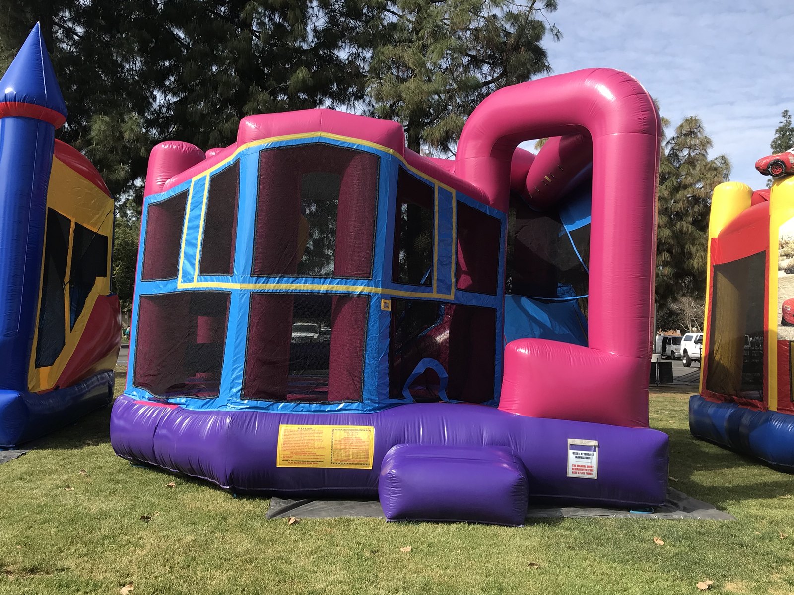 5n1 pink banner combo bounce house rental in San Diego, side view of the mesh safety windows and tall pink slide tower
