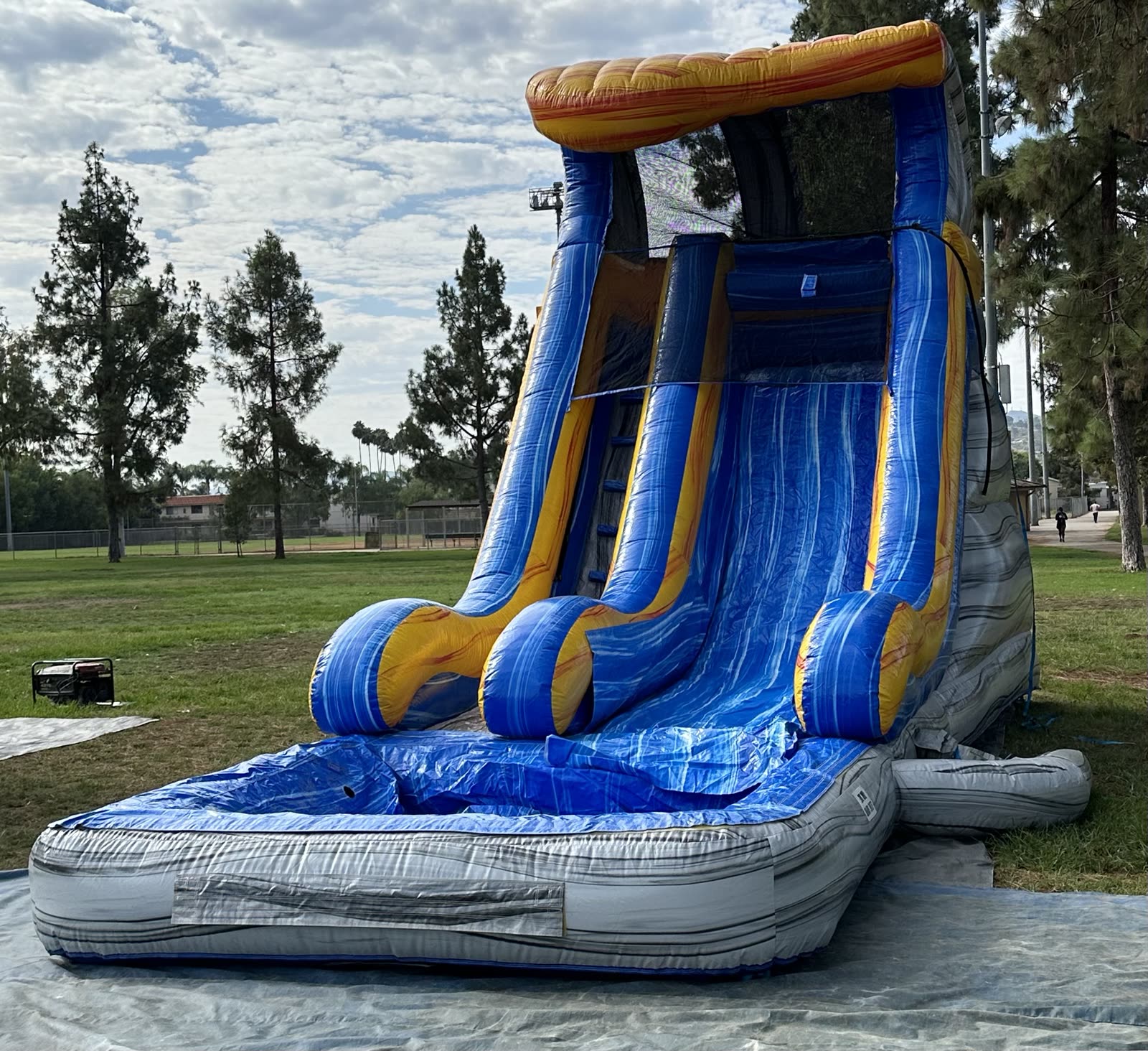 Water slide rental in San Diego, 18ft tidal wave setup three quarter view showing the splash pool landing and tarp