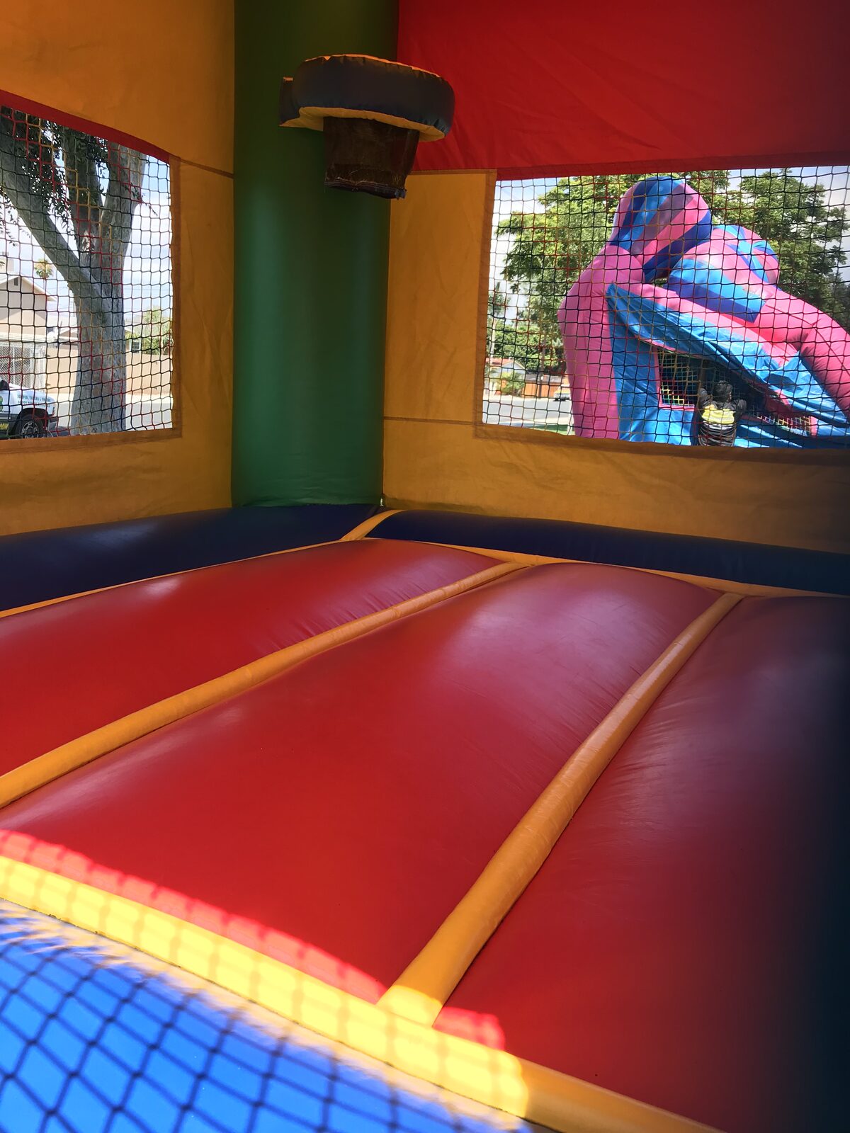 2n1 multi color castle banner combo bounce house rental in San Diego, interior close-up of the padded jump floor and mesh safety windows