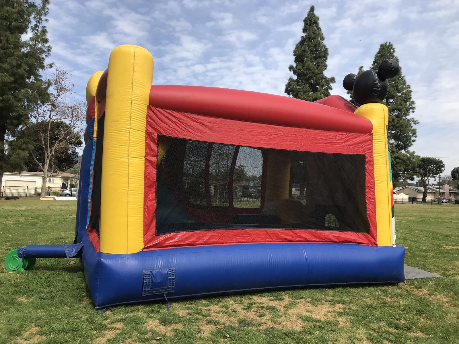 4n1 Mickey combo bounce house rental in San Diego, opposite side view showing the slide bump-out and blower hookup on park grass