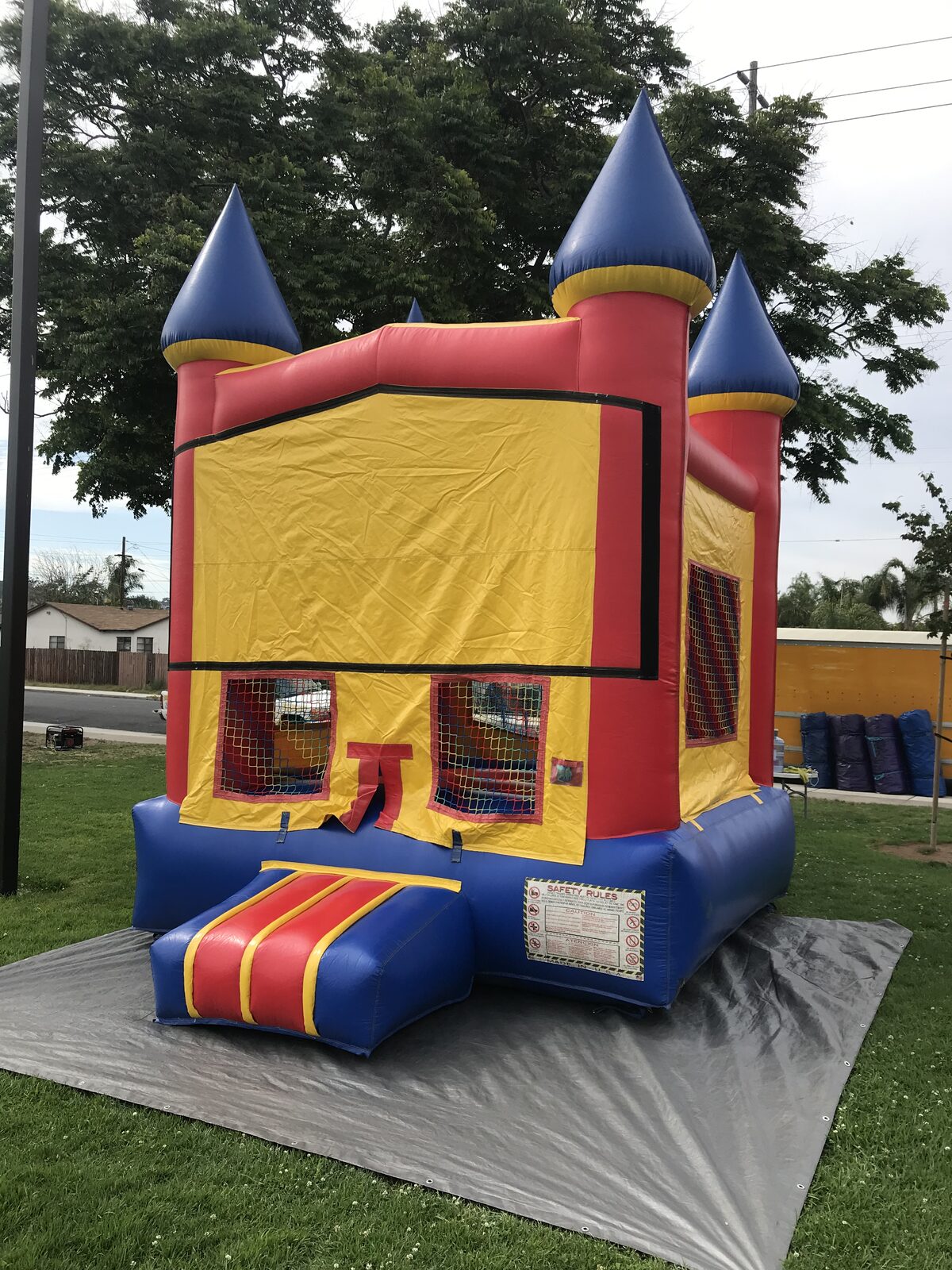 12x14 blue castle banner mini bounce house rental in San Diego, three-quarter view showing the side mesh window