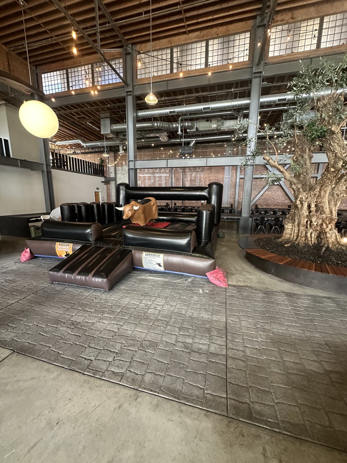Mechanical bull rental in San Diego, 13x13 setup on a stamped-concrete patio at an indoor-outdoor venue