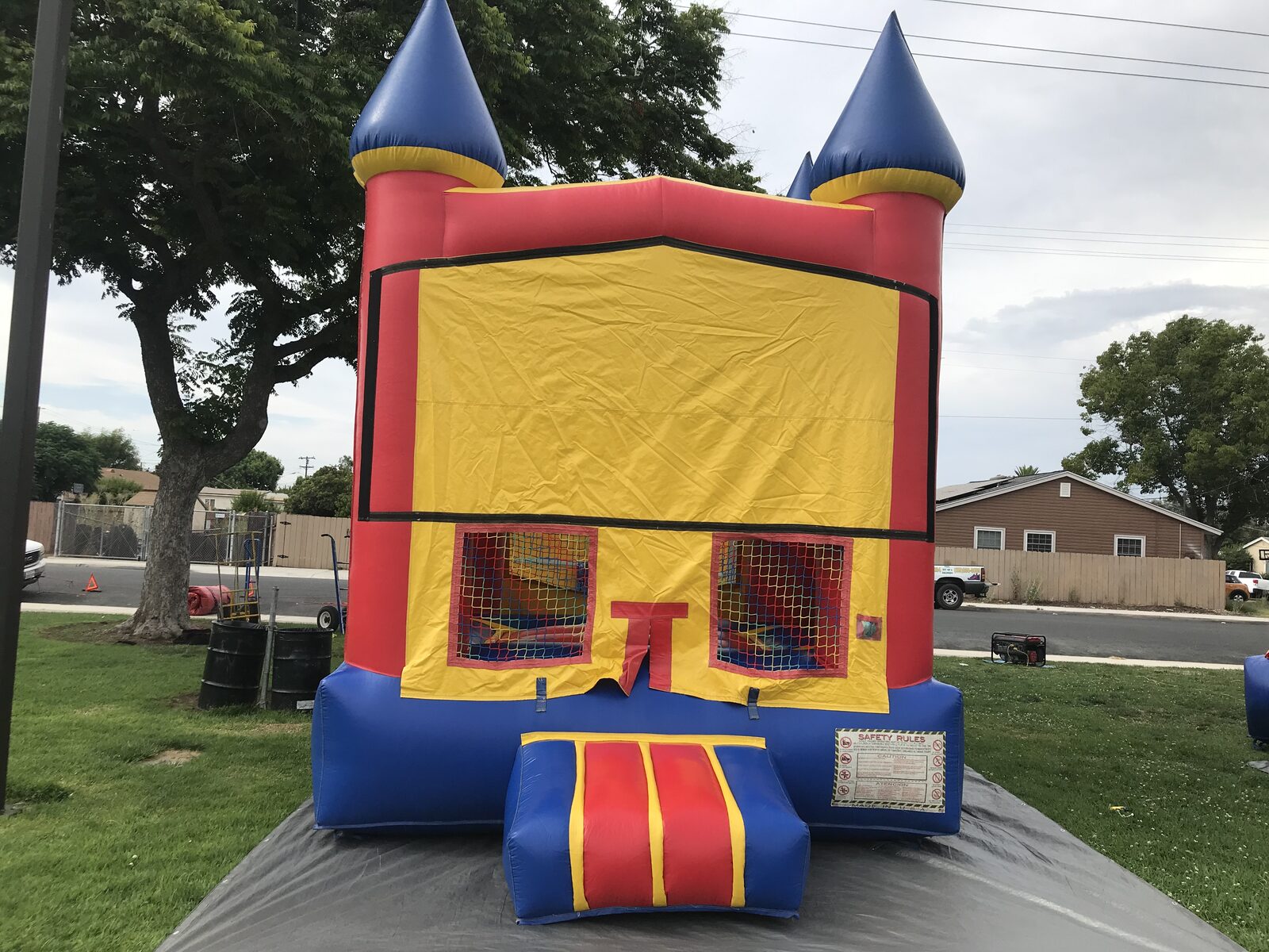 12x14 blue castle banner mini bounce house rental in San Diego, wide front view on a tarp in a park