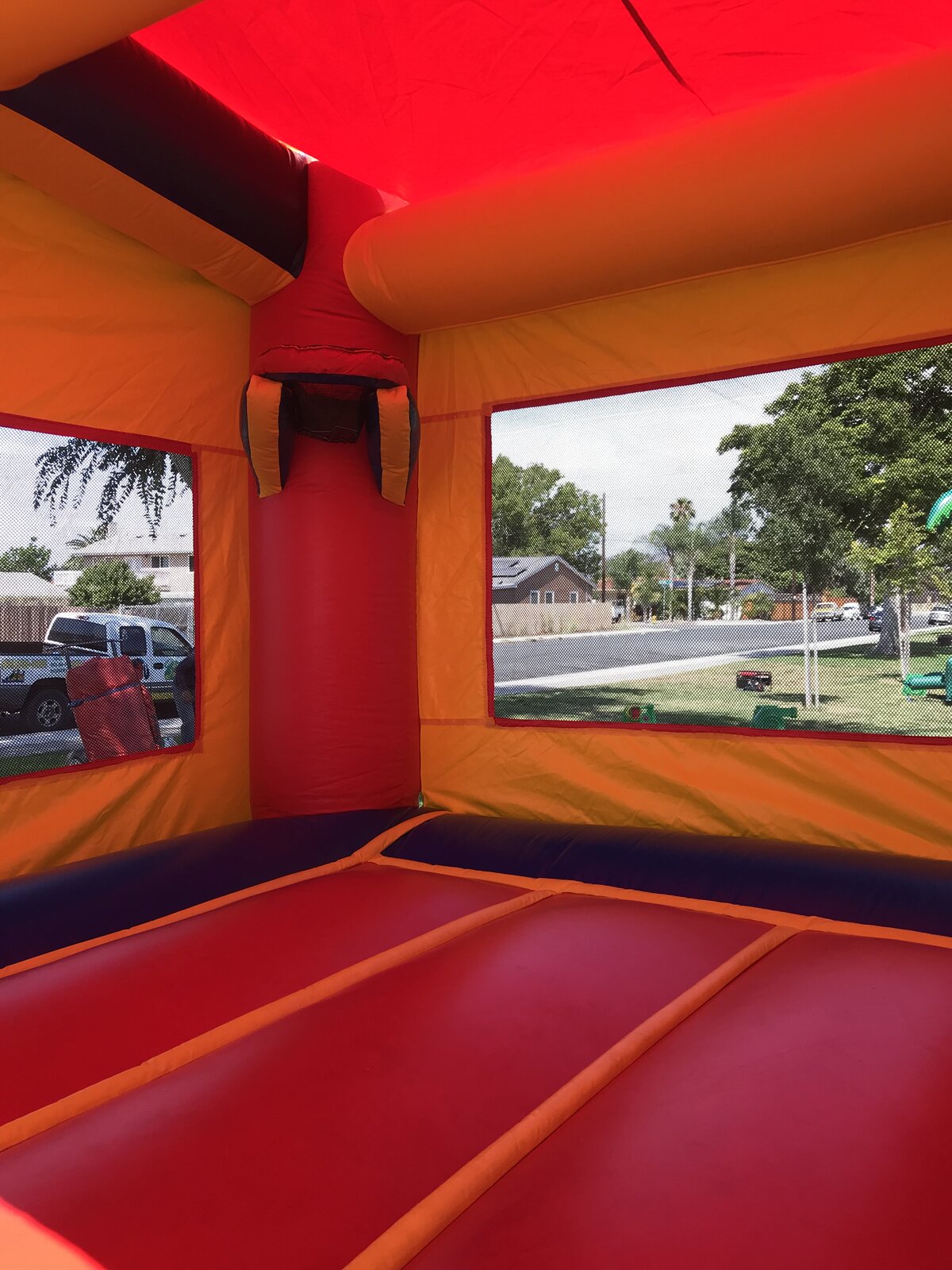 3n1 blue castle banner combo bounce house rental in San Diego, interior view of the padded jump floor, basketball hoop, and mesh safety windows