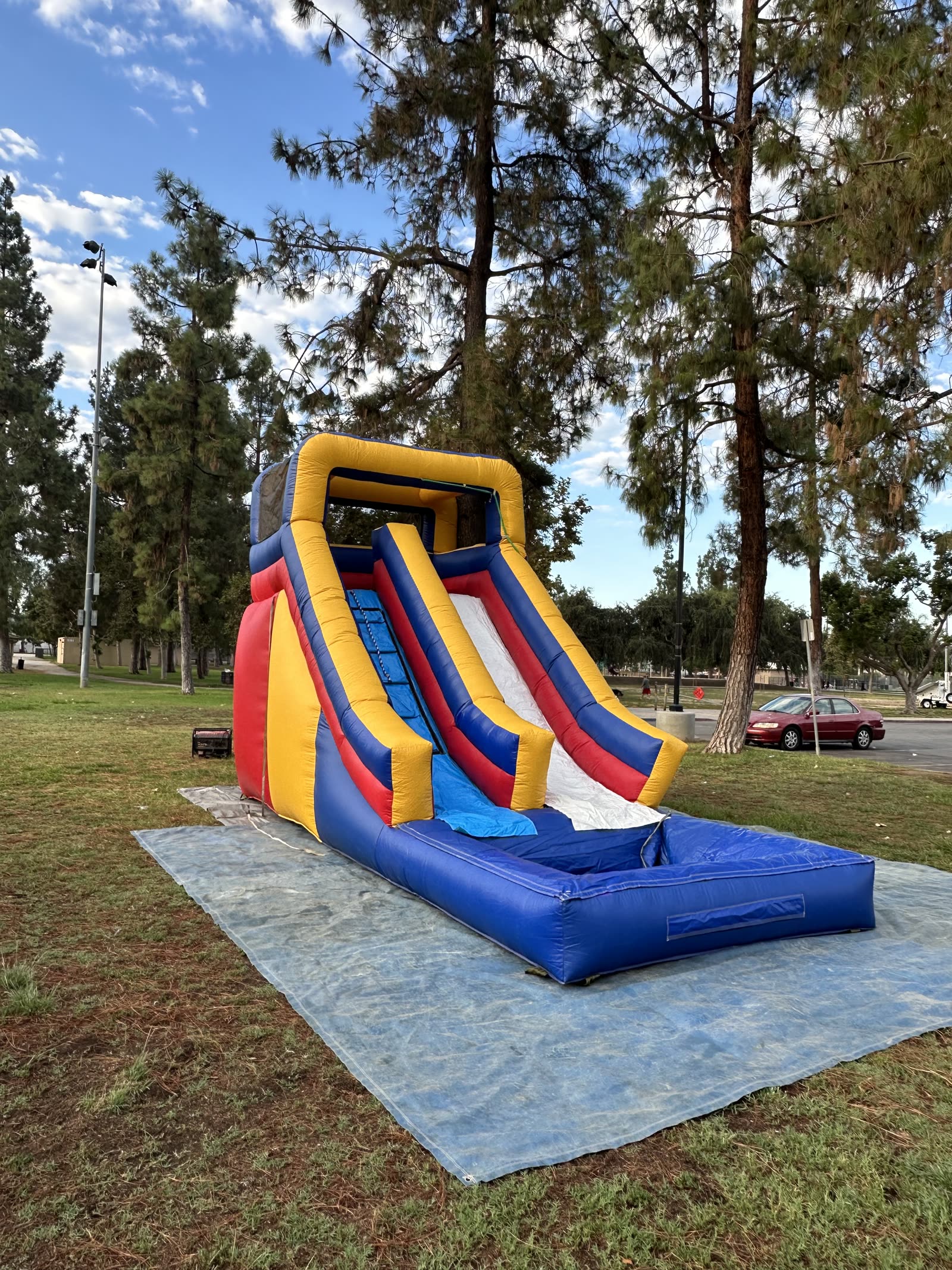 Water slide rental in San Diego, 15ft multi color water slide side profile on grass showing the slide height