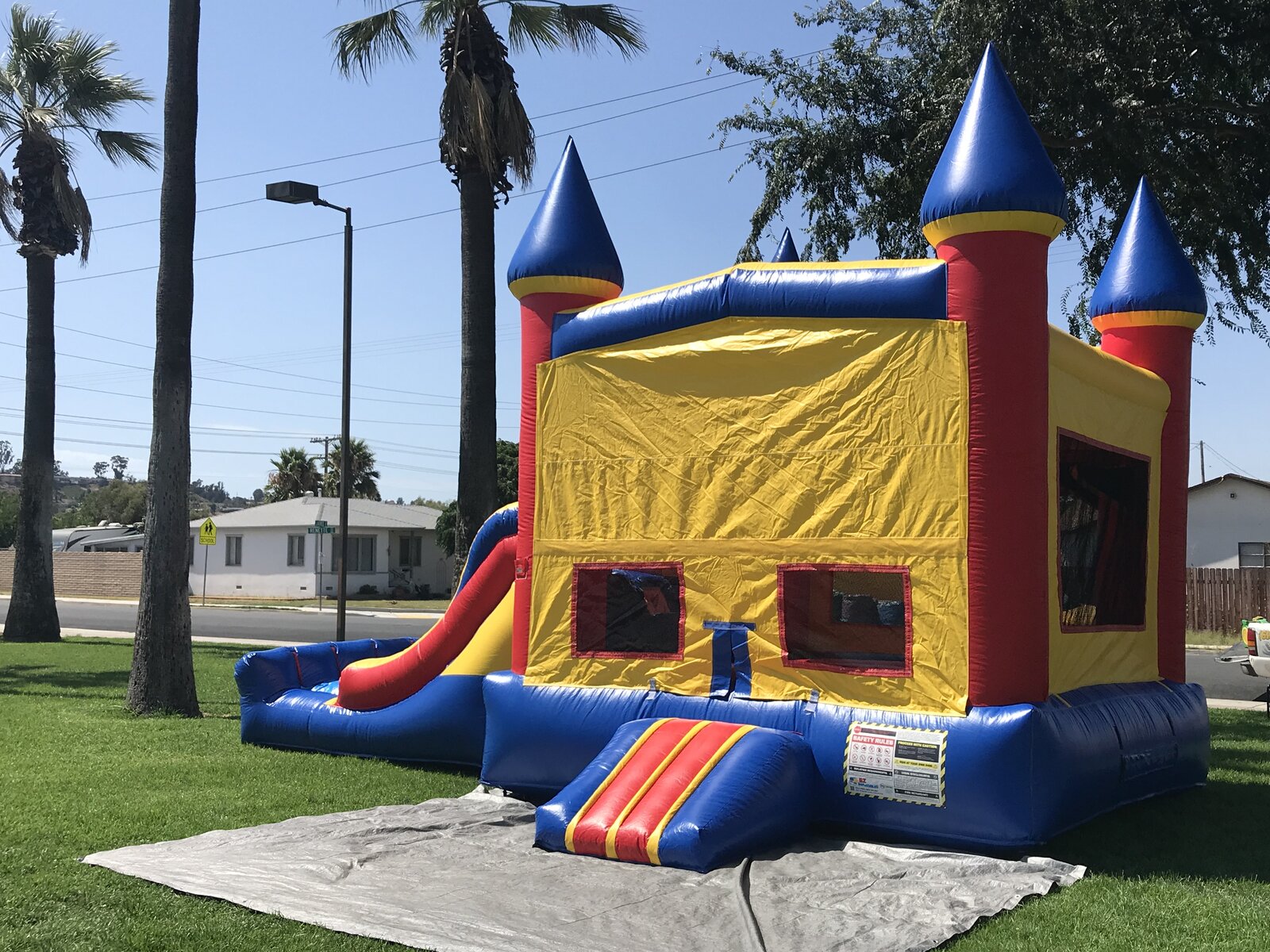 3n1 blue castle banner combo bounce house rental in San Diego, three-quarter view showing the blue turrets, mesh windows, and step-up entry
