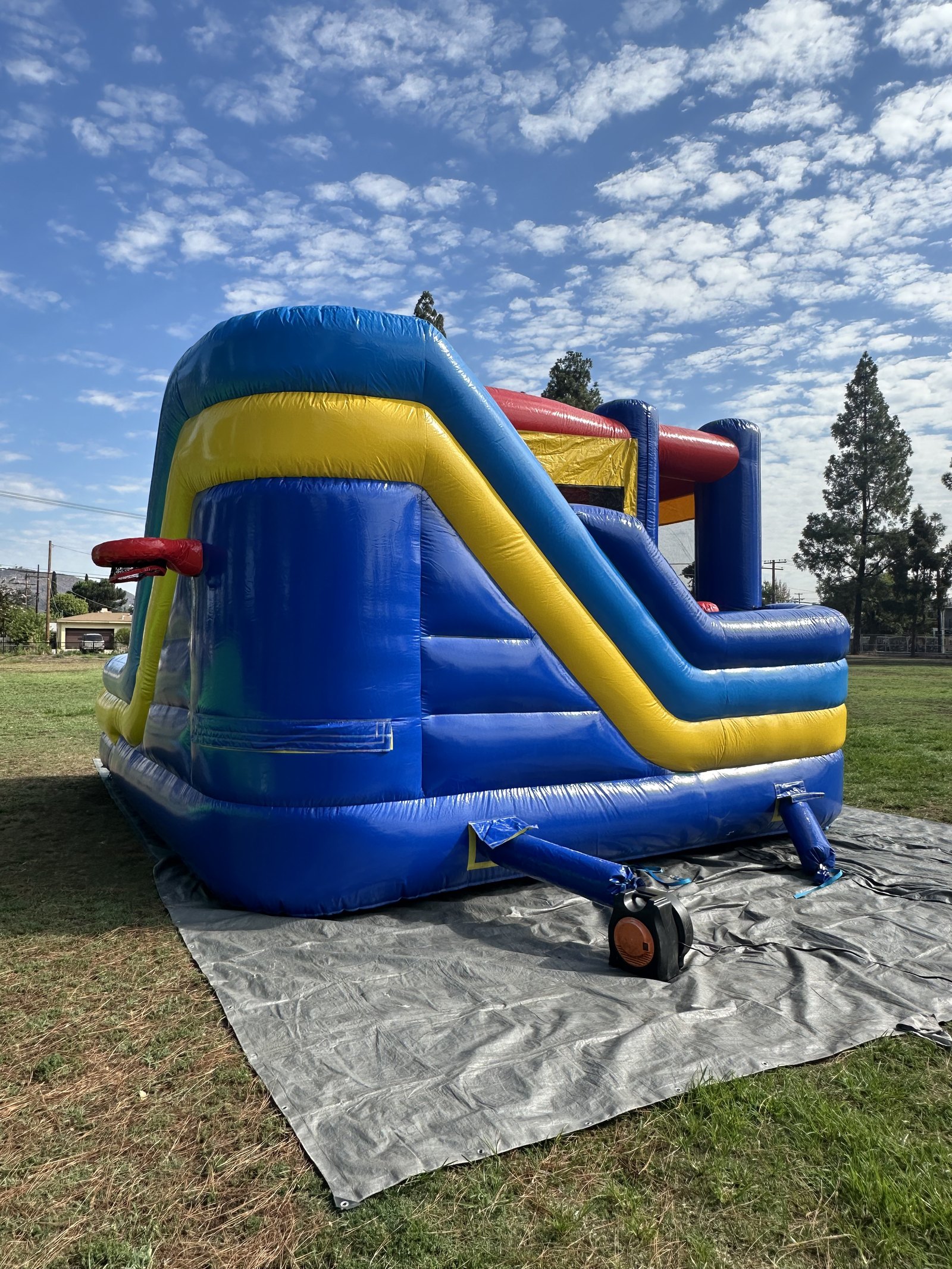 6n1 blue castle combo bounce house rental in San Diego, close view of the tall slide side and exterior basketball hoop