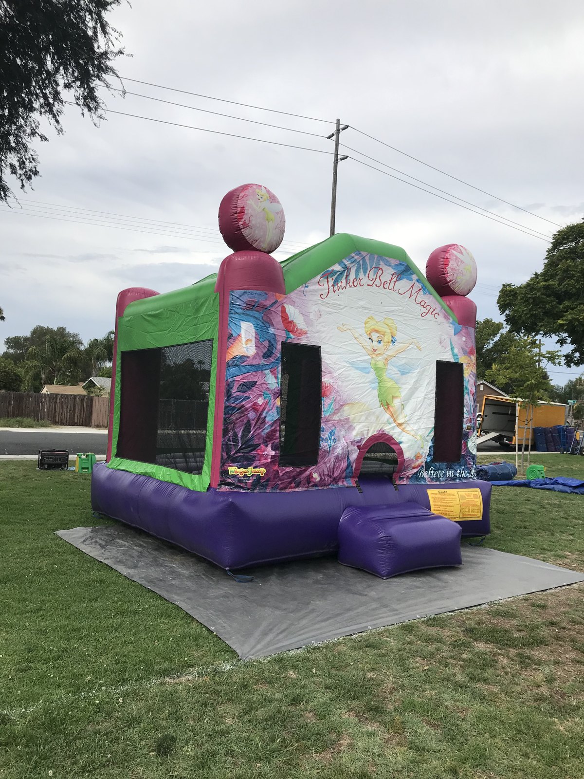 13x13 Tinkerbell bounce house rental in San Diego — angled view showing the mesh side walls and purple base