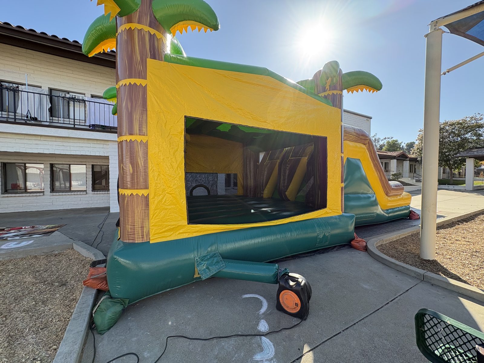 4n1 tropical oasis dual slide combo bounce house rental in San Diego, rear corner view of the palm tree tower and jump area