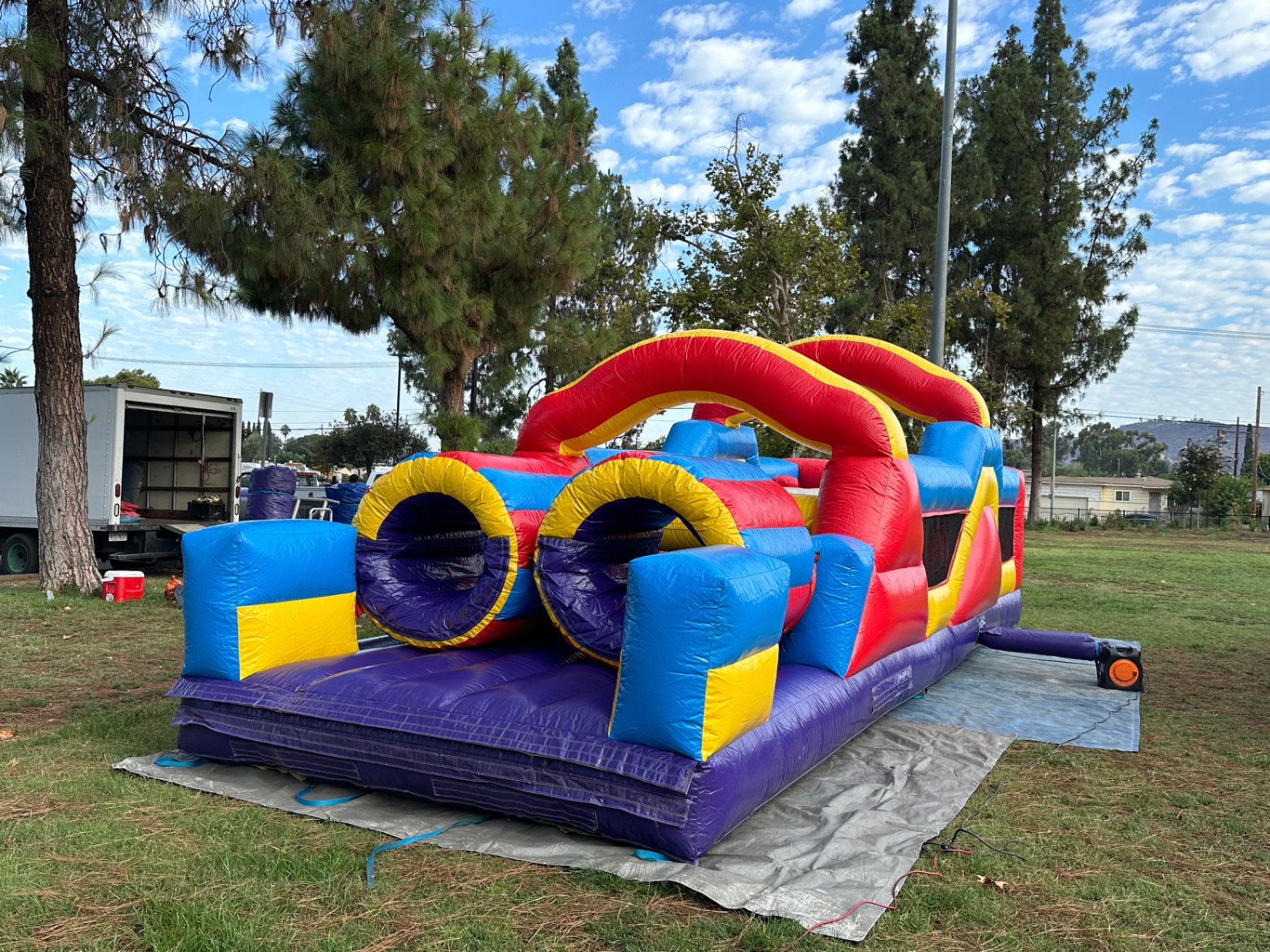 33ft monster obstacle course rental in San Diego, purple crawl tunnels at the course entry on a park lawn