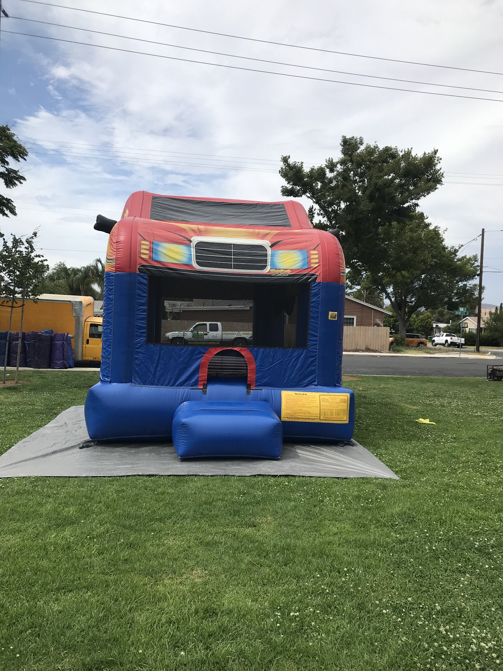 13x17 Xtreme Racer bounce house rental in San Diego — straight-on front view of the race car unit with flame graphics and grille over a blue base