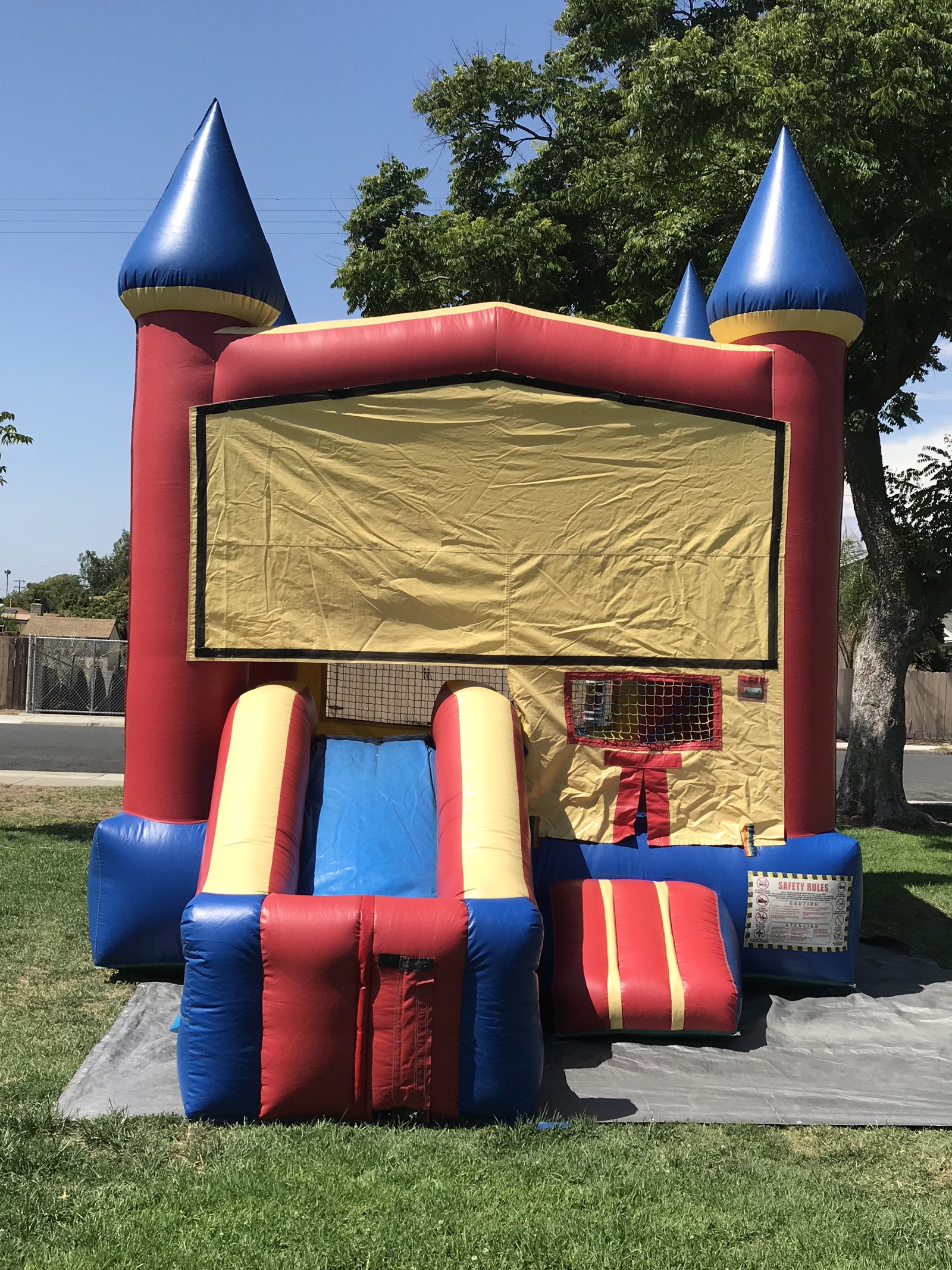 2n1 blue castle combo bounce house rental in San Diego, straight-on front view showing the blank banner panel and basketball hoop window