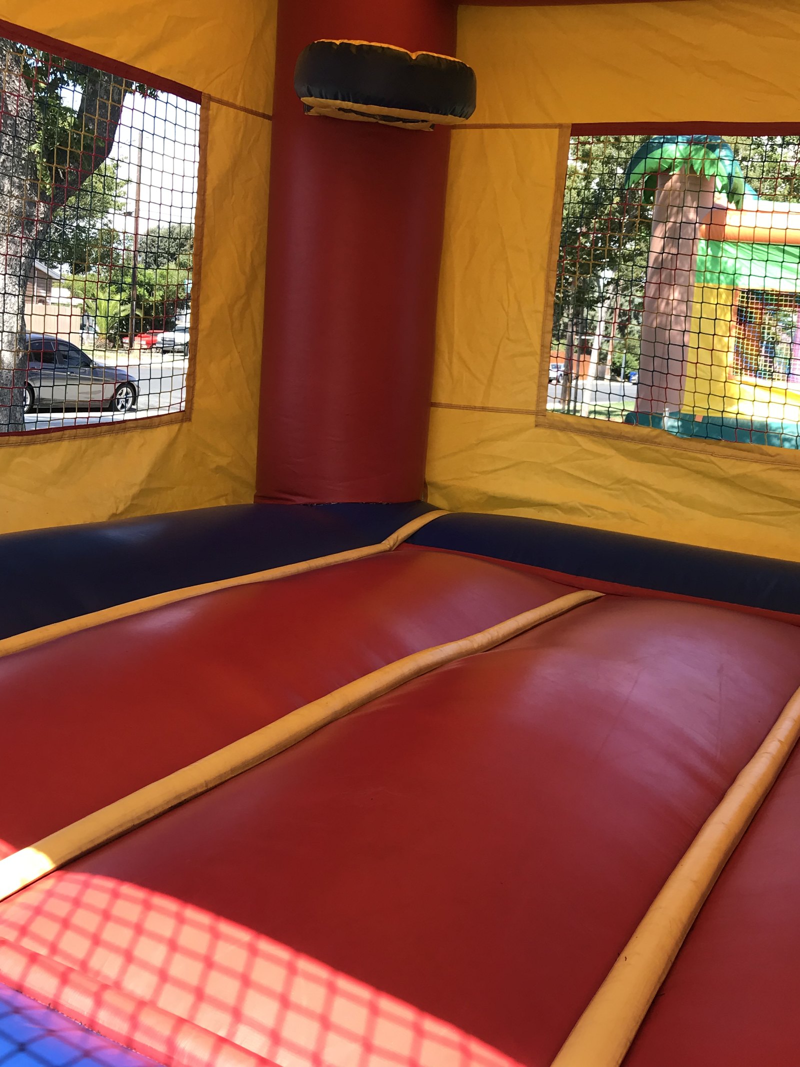 2n1 blue castle combo bounce house rental in San Diego, inside view of the padded red jump floor with mesh safety windows