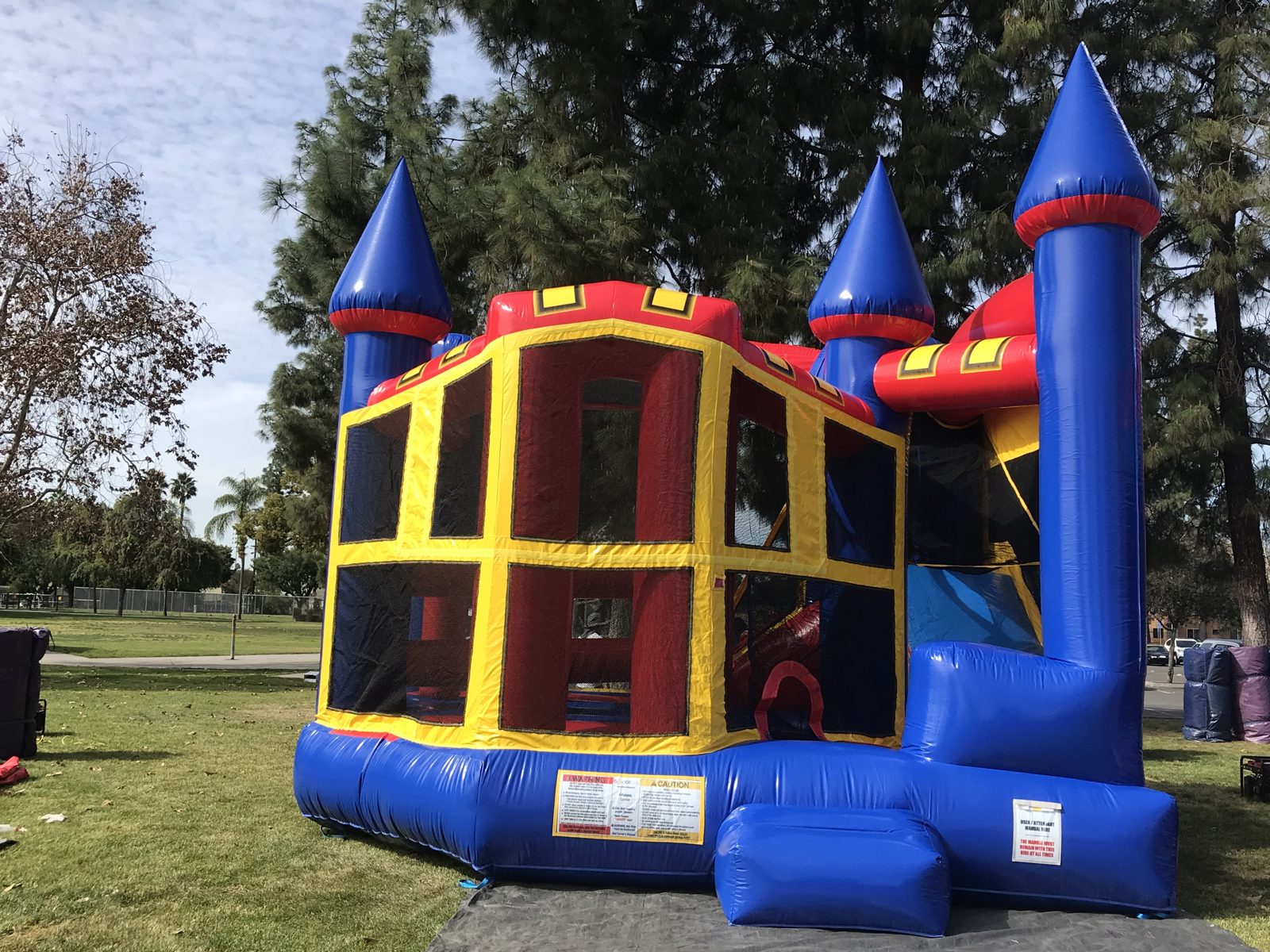 5n1 blue castle banner combo bounce house rental in San Diego, close angled view of the red roof trim and blue entry step