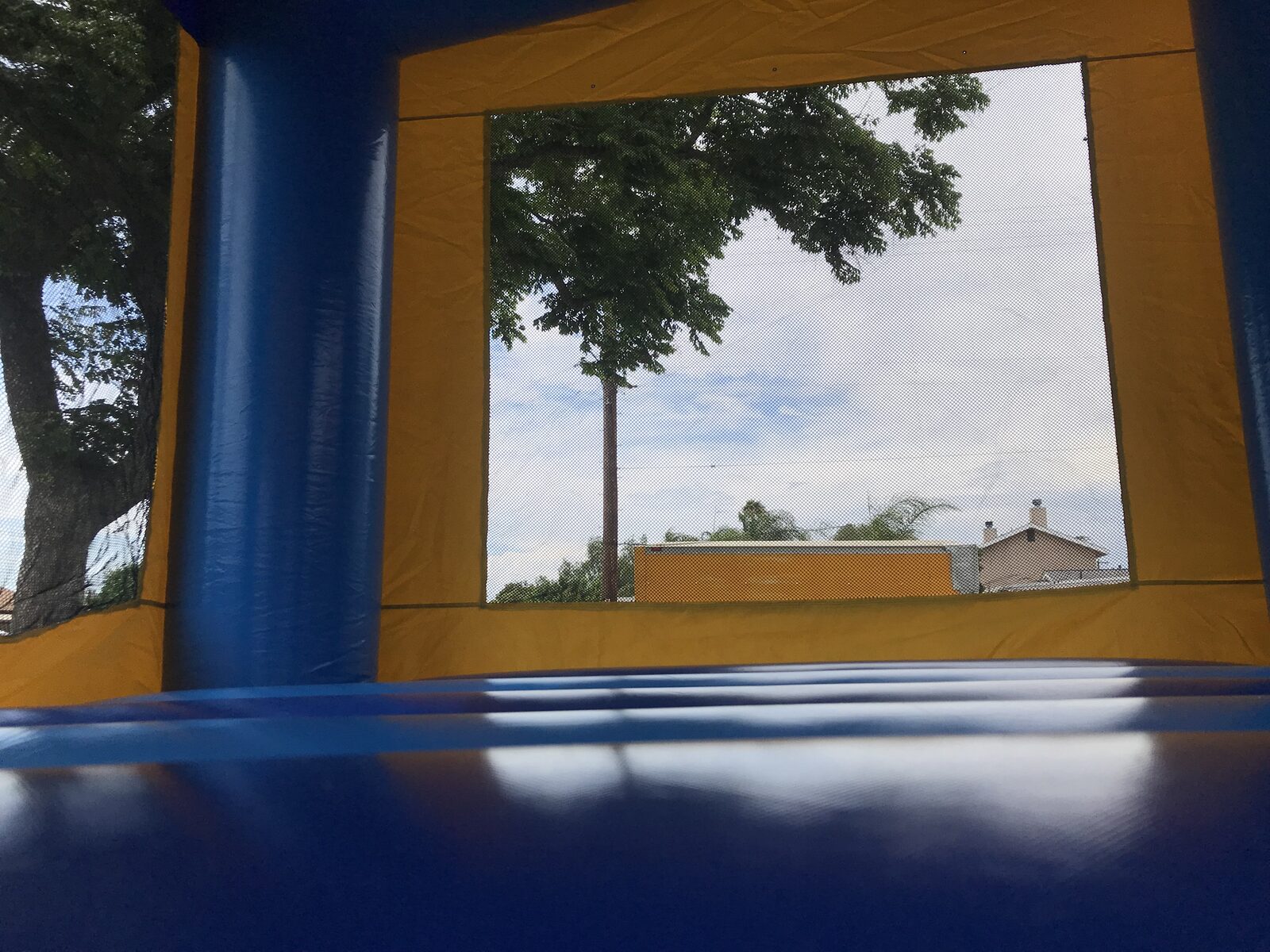 13x13 blue banner bounce house rental in San Diego — inside view of the blue jumping floor and large mesh safety window