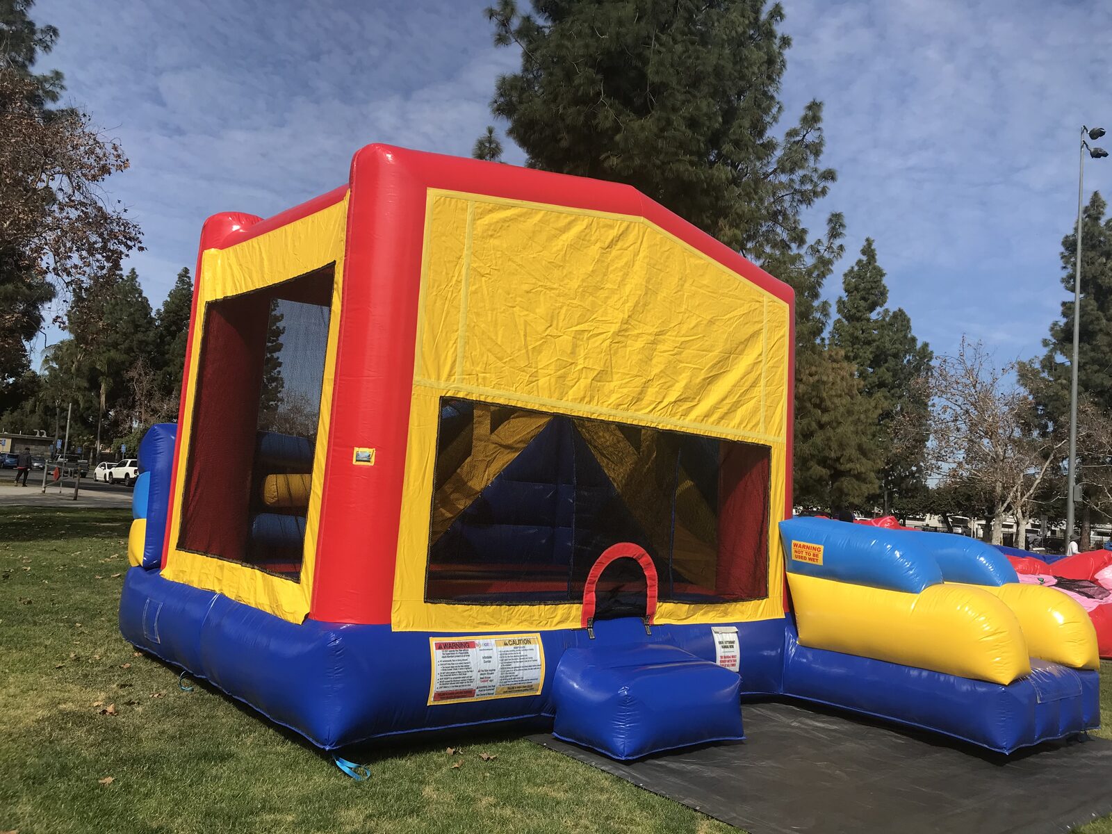 6n1 banner combo bounce house rental in San Diego, side view of the slide lane and inflatable landing bumper