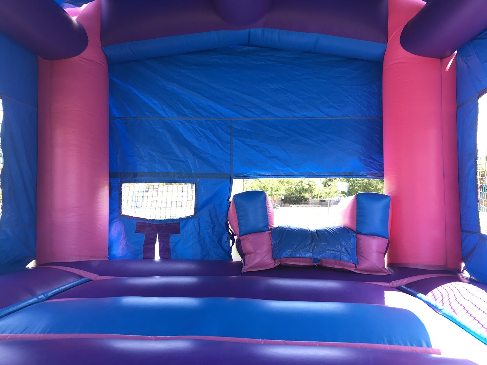 2n1 pink castle banner combo bounce house rental in San Diego, wide interior view looking toward the slide entry and jump area