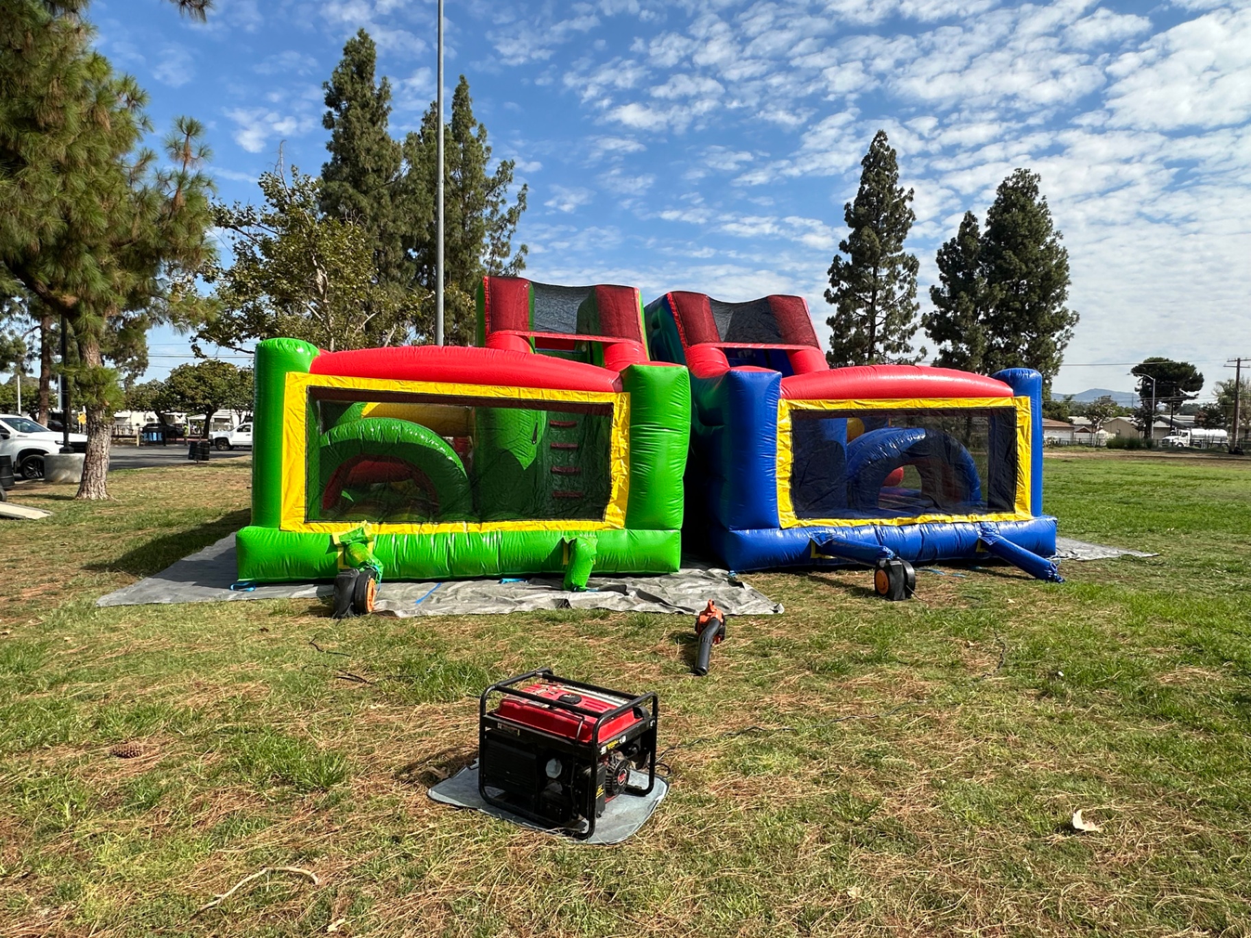 Dual lane challenge course obstacle rental in San Diego, rear view of both lanes with the blower and generator set up on the grass
